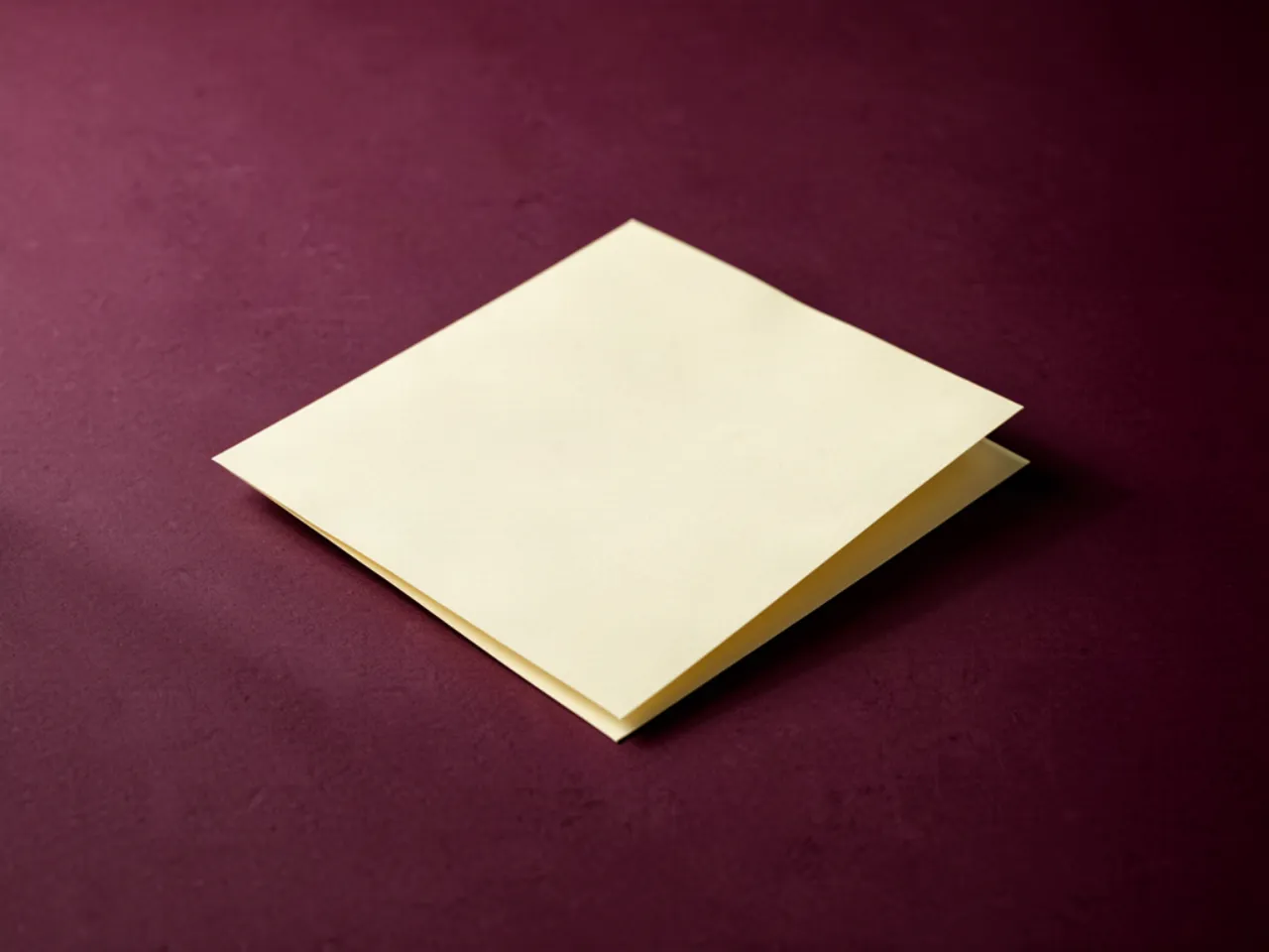 A single folded sheet of paper on an empty plum surface